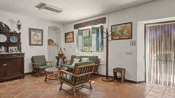 A traditional living room with a fireplace, a dining table, and a sofa.