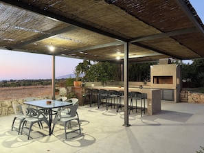 An outdoor patio with a table and chairs, a grill, and a view of the landscape. -  Spacious 6-bedroom house in beautiful Poli Chrysochous with AC (Poli Chrysochous)