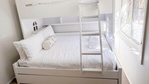 A bunk bed with a ladder, white bedding, and a window with a view of greenery. - Samson Sea-clusion 3 bedroom home in Vincentia (Vincentia)