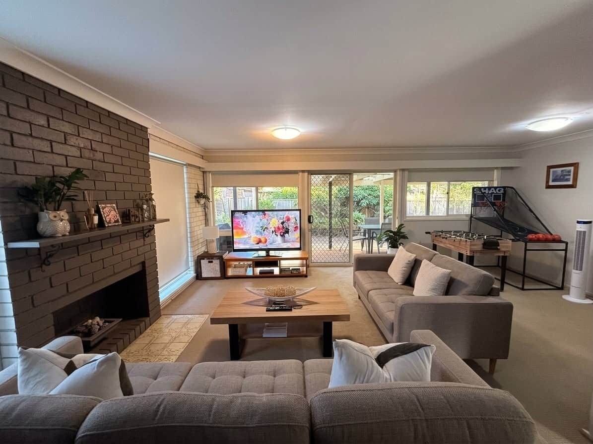 A living room with a fireplace, a television, and a sofa.
