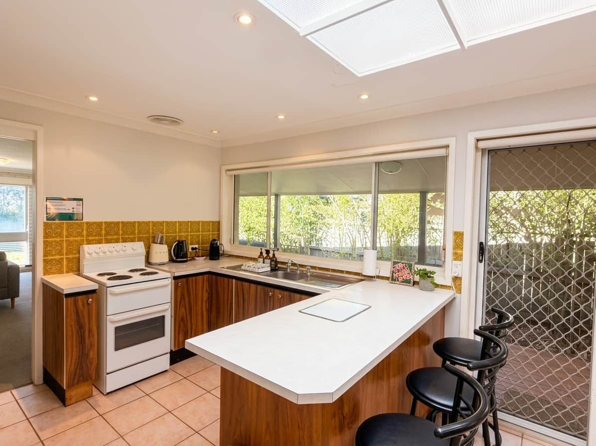 A modern kitchen with a central island, a stove, and a sink.