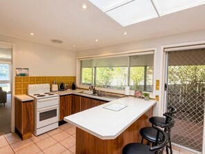 A modern kitchen with a central island, a stove, and a sink.