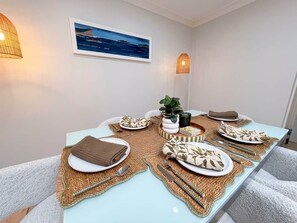 A dining table set with placemats, plates, cutlery, and a centerpiece.
