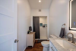 Un baño pequeño con inodoro, lavabo y zona de ducha.