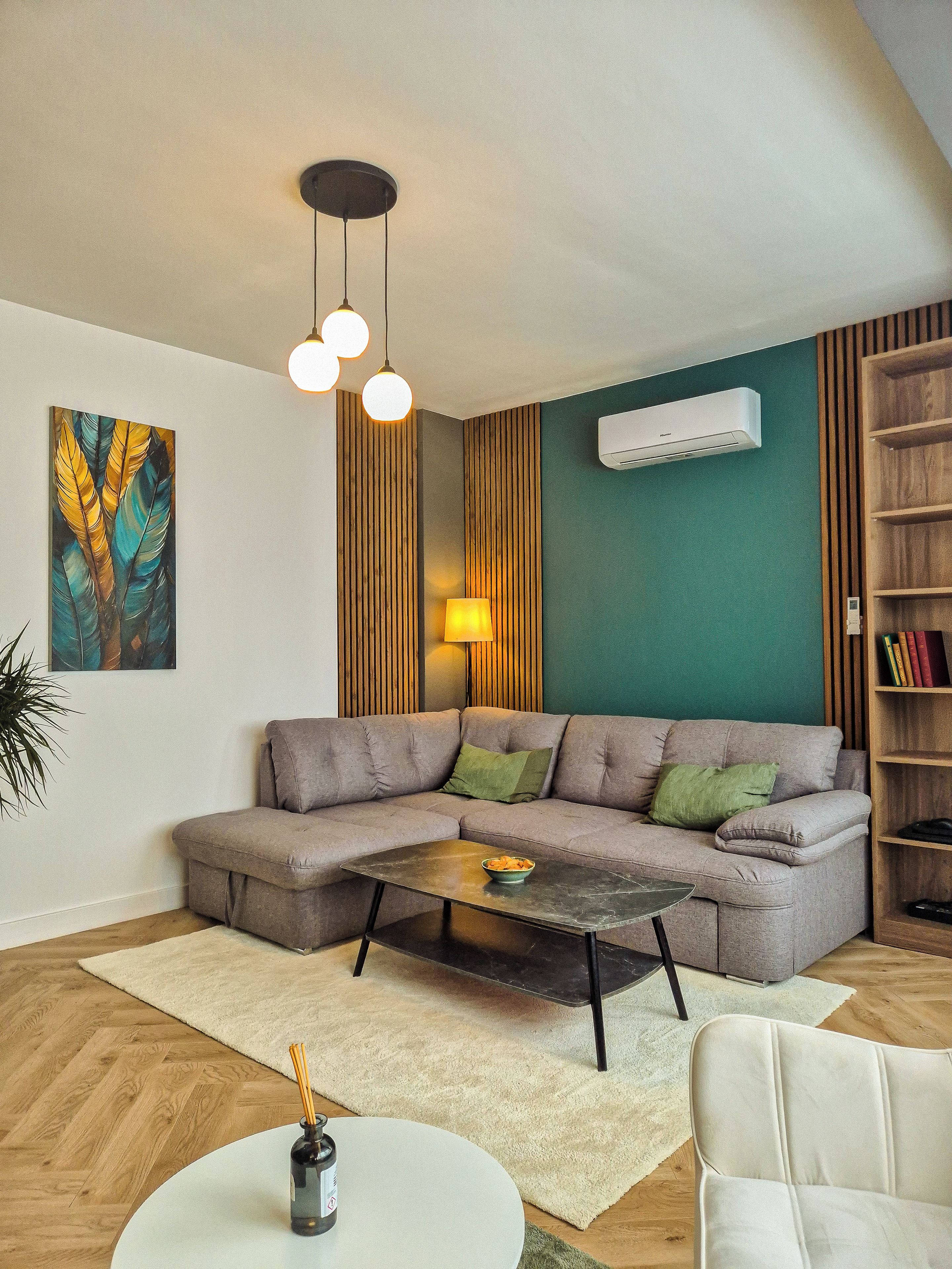 A modern living room with a sectional sofa, a coffee table, a lamp, and a bookshelf.
