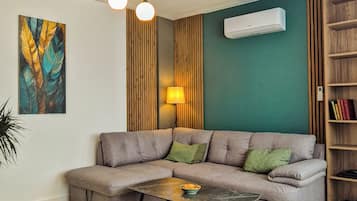 A modern living room with a sectional sofa, a coffee table, a lamp, and a bookshelf.