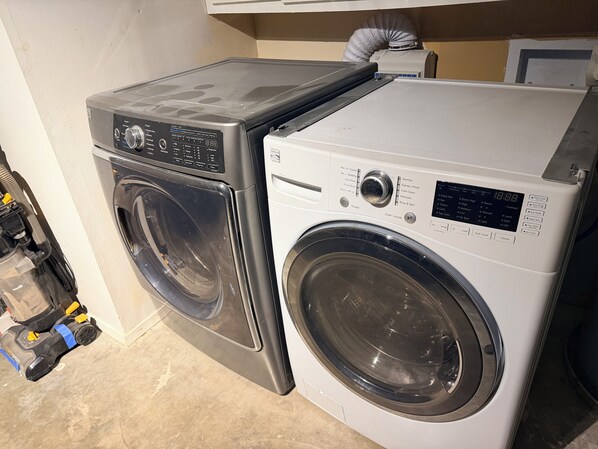 A front-loading washing machine and dryer side by side in a laundry room.