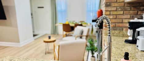 Una cocina con encimera de granito, pileta de acero inoxidable y grifo moderno.