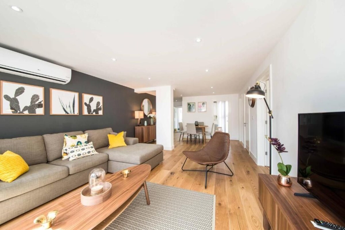 A modern living room with a sofa, coffee table, and a television.