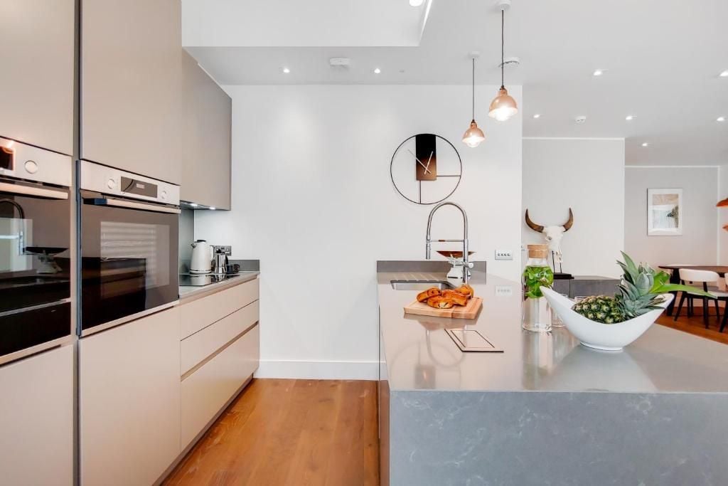 A modern kitchen with a central island, stainless steel appliances, and pendant lighting.