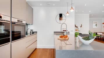 A modern kitchen with a central island, stainless steel appliances, and pendant lighting.