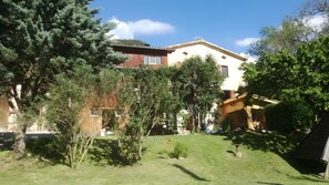 Una zona residencial con una casa, césped y árboles.