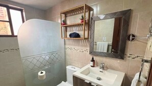 Ein Badezimmer mit Toilette, Waschbecken und Duschbereich.