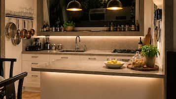 A modern kitchen with a central island, pendant lighting, and a window above the sink.