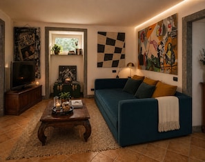 A living room with a sofa, coffee table, and a television. - Casa Rubinacci (Napoli)