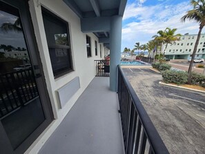 A hotel balcony with a view of a swimming pool and palm trees. - Free Parking Beach Condo - Beach Terrace (Hollywood)