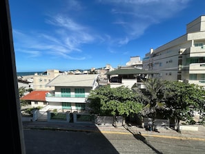 A residential area with buildings, a paved street, and a view of the sea. - Mirante do Oceano Hospedaria (Bombinhas)