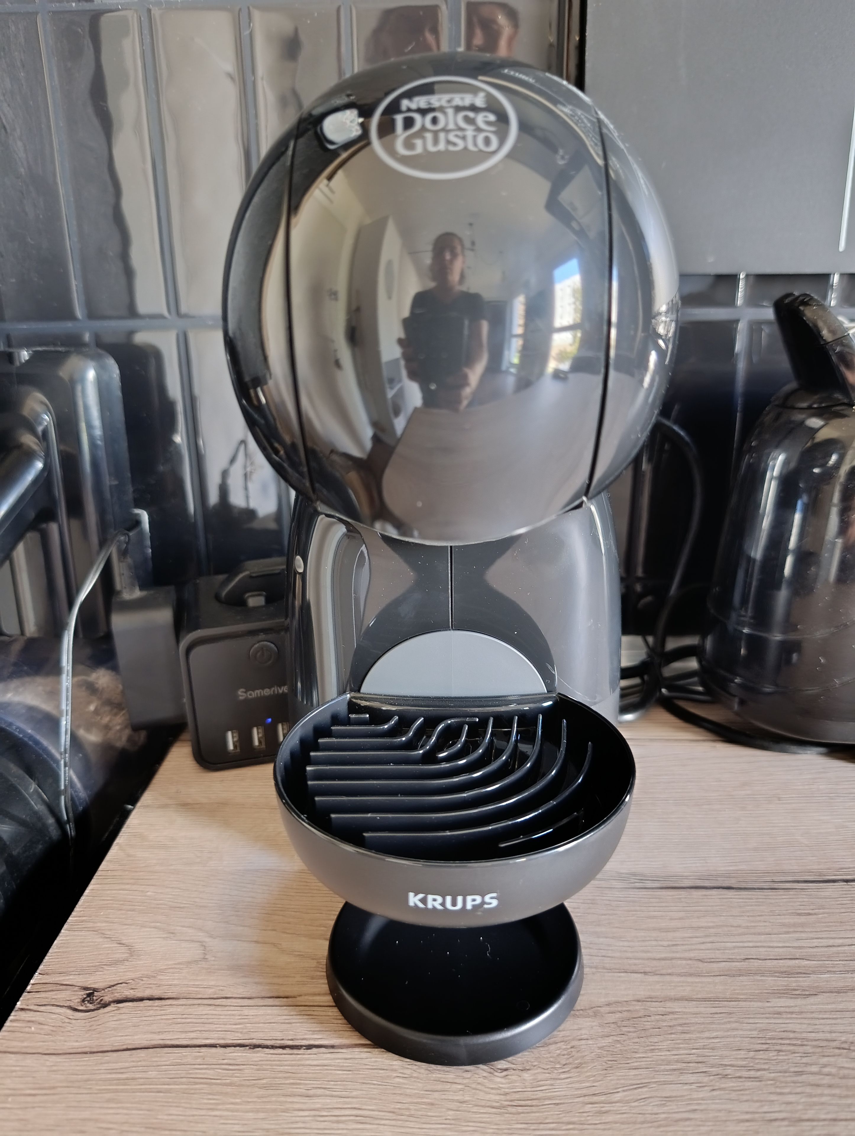 Un plan de travail de cuisine avec une machine à café, une bouilloire et un moulin à café.