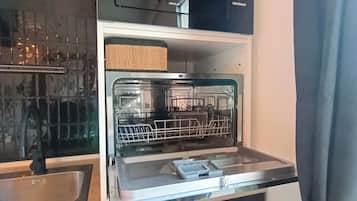 A compact kitchen with a microwave, dishwasher, and a sink.