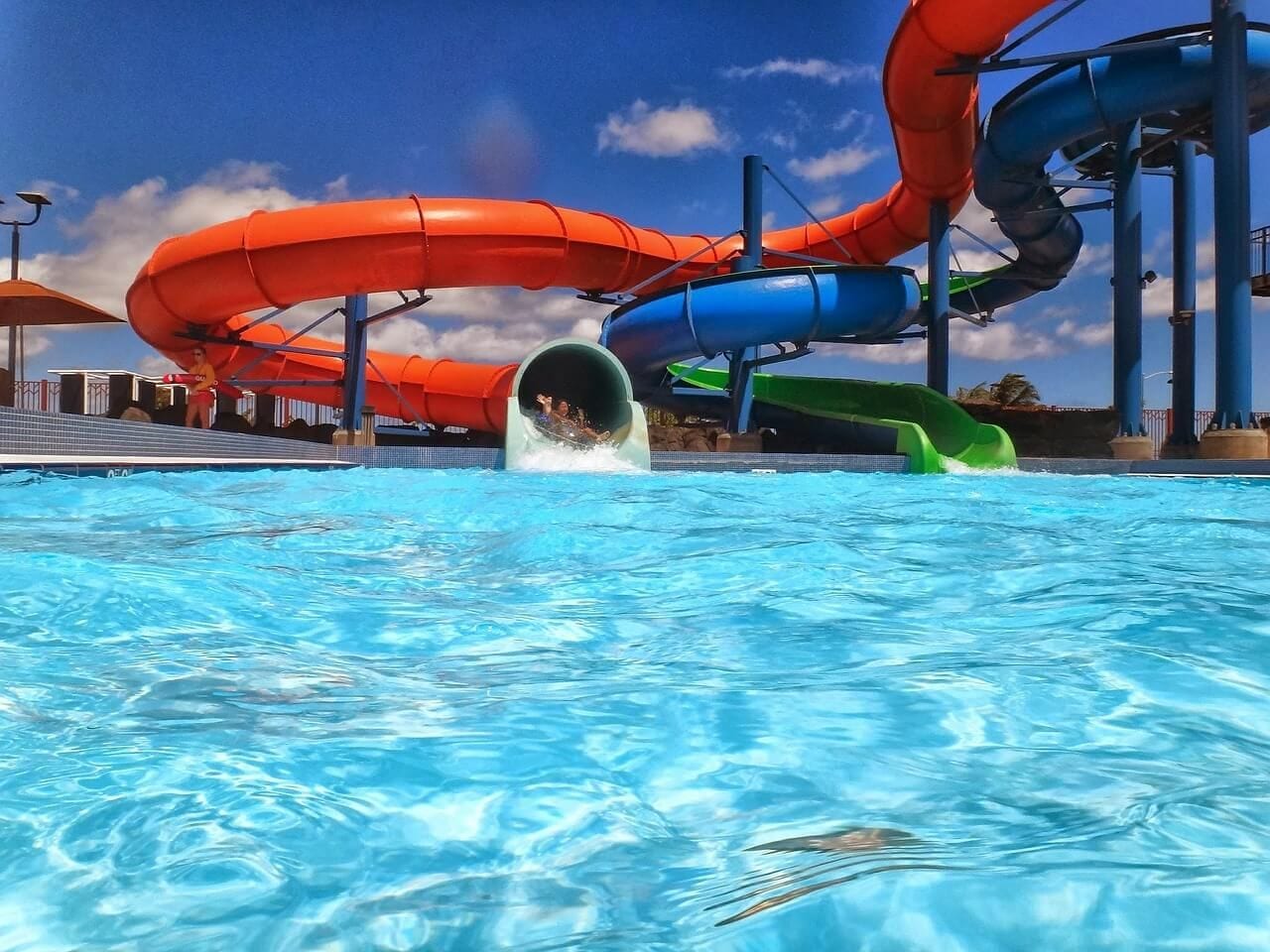 Een waterpark met meerdere glijbanen en een zwembad.