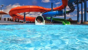 Een waterpark met meerdere glijbanen en een zwembad.