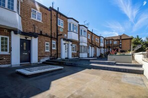 A row of terraced houses with a paved courtyard. - Elegant Moor Park Home With Golf Club &amp; London City Centre Access (Northwood)