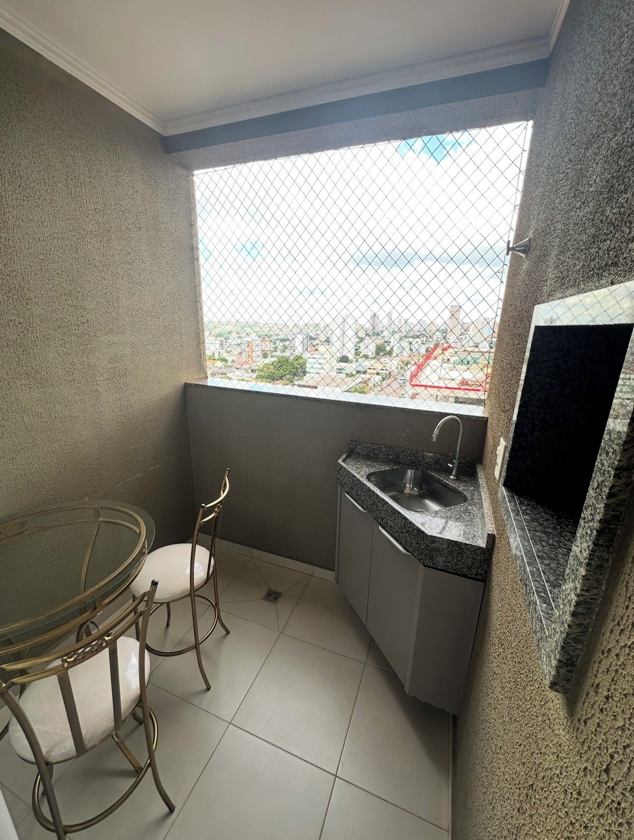 Una pequeña kitchenette con un lavamanos, una silla y una mesa de comedor.