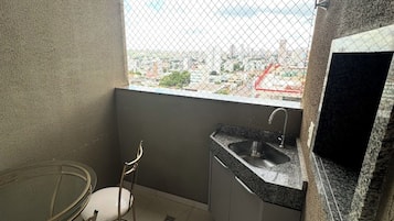 Una pequeña kitchenette con un lavamanos, una silla y una mesa de comedor.