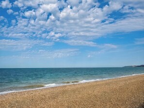 A beach with pebbly shore, calm sea, and a partly cloudy sky. - Sea View Luxury Apartment Sleeps 5 - Fast Wifi - off Street Parking - Contractors Dream (Sheerness)