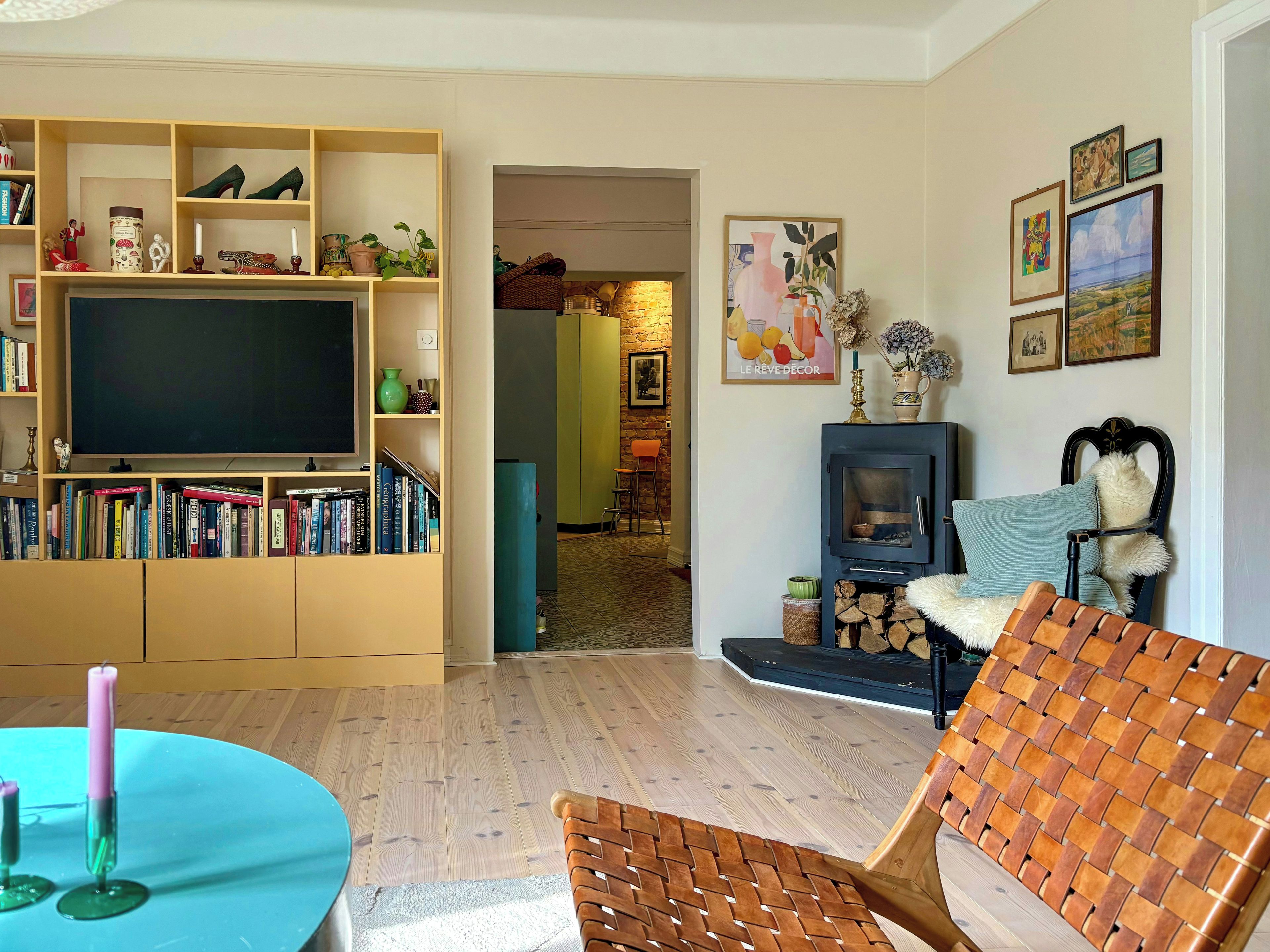 Een woonkamer met een televisie, een boekenkast en een open haard.