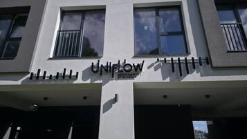 A building with a sign that reads 'UNIFLOW APARTMENTS BY RIXWELL'.