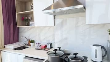Une cuisine moderne équipée d’un four encastré, d’une cuisinière et d’une bouilloire.