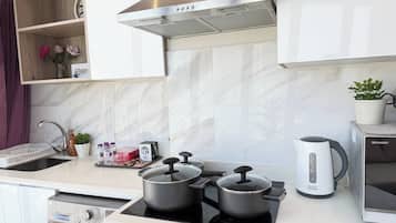 Une cuisine moderne équipée d’un four encastré, d’un four à micro-ondes et d’une bouilloire.