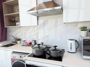 A modern kitchen with a built-in oven, a microwave, and a kettle.