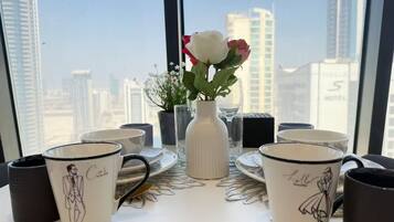 Une table avec un vase de fleurs et une vue sur la ville.