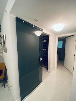 A room with a sliding door, a ceiling light, and a door leading to another room. -  Luxury Designer-Furnished 2BR with 2 Large Terraces in Bay Harbor (Bay Harbor Islands)