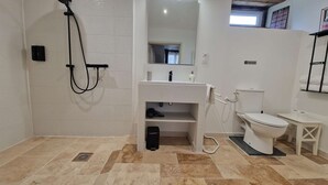 Ein Badezimmer mit Waschbecken, Toilette und Duschbereich.