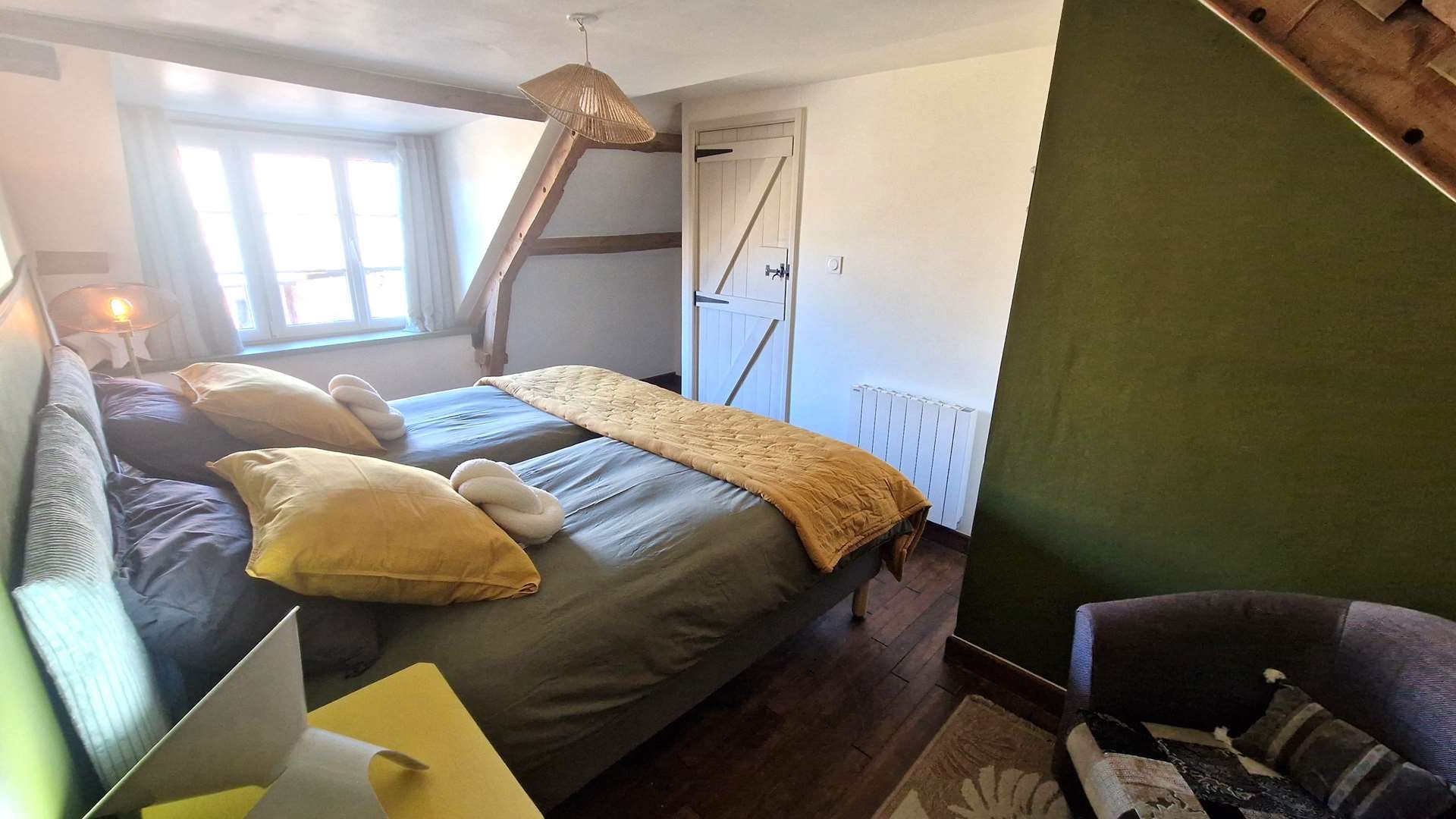 Un dormitorio con una cama, un escritorio, una silla y una ventana.