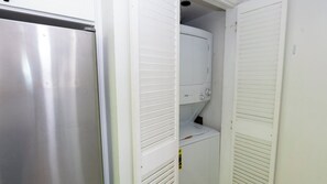 A compact kitchen with a stainless steel refrigerator, a built-in oven, and a white cabinet. - Saida Royale, Beachfront 10th Floor, 2BR, 3 Pools (South Padre Island)