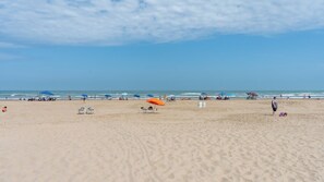 A wide sandy beach with umbrellas and beach chairs. - Saida Royale, Beachfront 10th Floor, 2BR, 3 Pools (South Padre Island)
