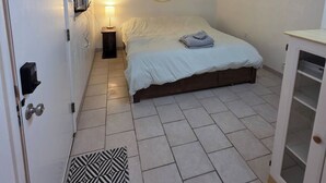 Ein Schlafzimmer mit Bett, Nachttischlampe, Klimaanlage und einer geometrischen Wanddekoration.