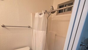 Ein Badezimmer mit Toilette, Dusche und Handtuchhalter.