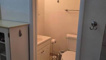 A compact bathroom with a toilet, a sink, and a small cabinet.