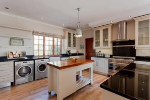 Una cocina moderna con una isla central, electrodomésticos de acero inoxidable y un amplio ventanal.