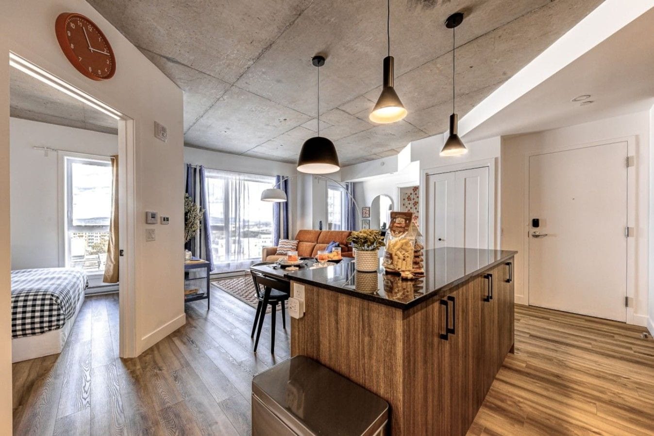 Une cuisine moderne dotée d’un îlot central, de luminaires suspendus et offrant une vue sur la ville.