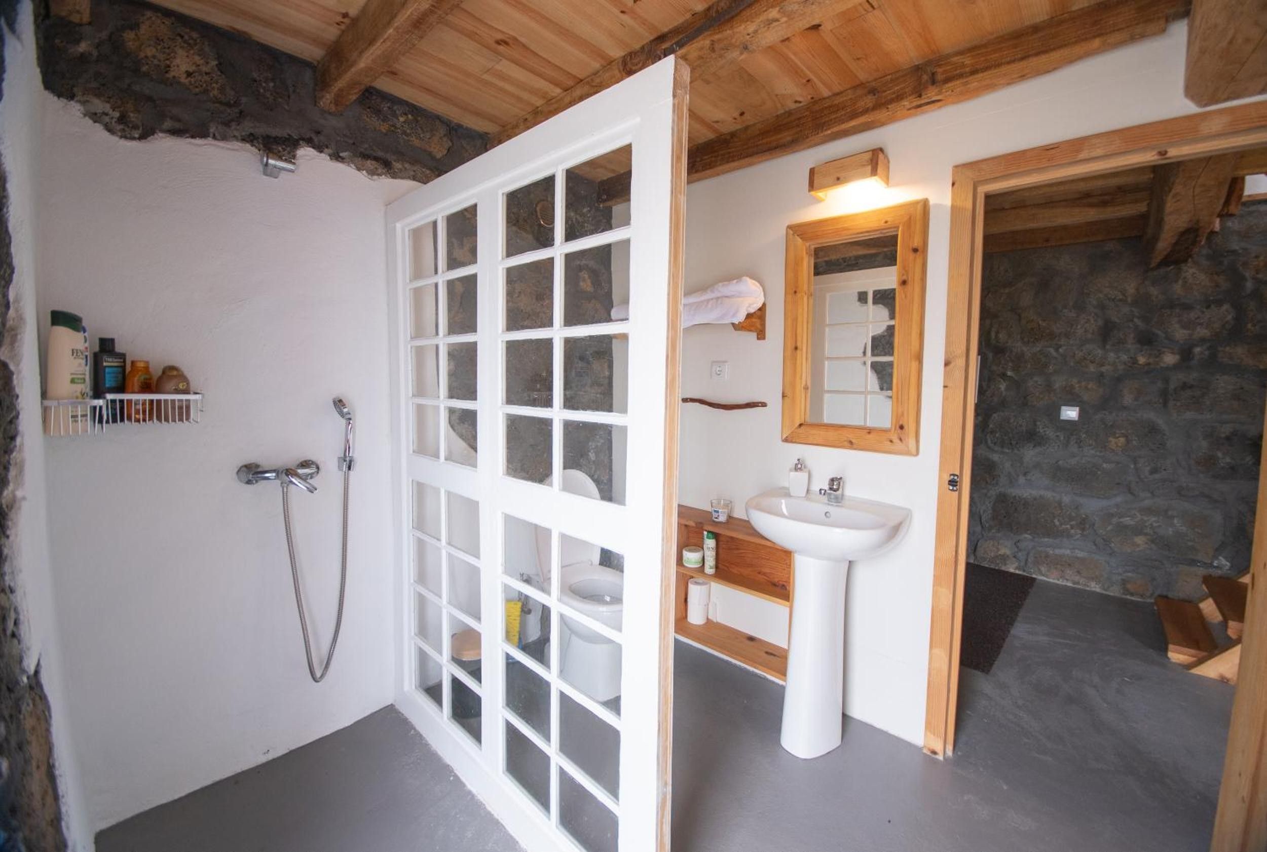 A bathroom with a shower, toilet, and sink.