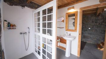 A bathroom with a shower, toilet, and sink.