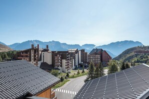 Un hôtel moderne à plusieurs étages, doté d’un parking et offrant une vue sur les montagnes en arrière-plan.