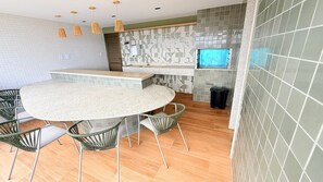 A modern kitchen with a round dining table, chairs, and a built-in oven.