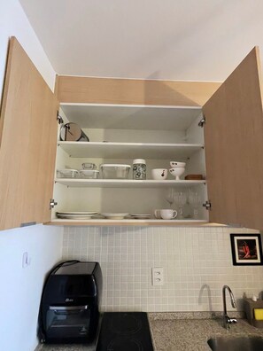 Eine Küche mit Backofen, Kaffeemaschine und einer gefliesten Spritzschutzwand.